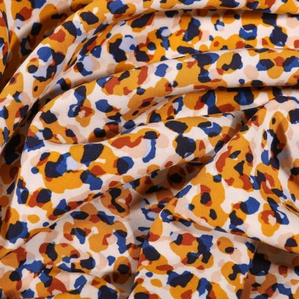 Tissu Viscose Tapis de fleurs jaune orangé sur fond Blanc - Par 10 cm