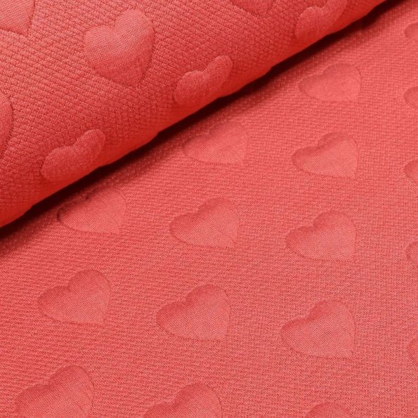Tissu Sweat Cœurs en relief sur fond Corail - Par 10 cm