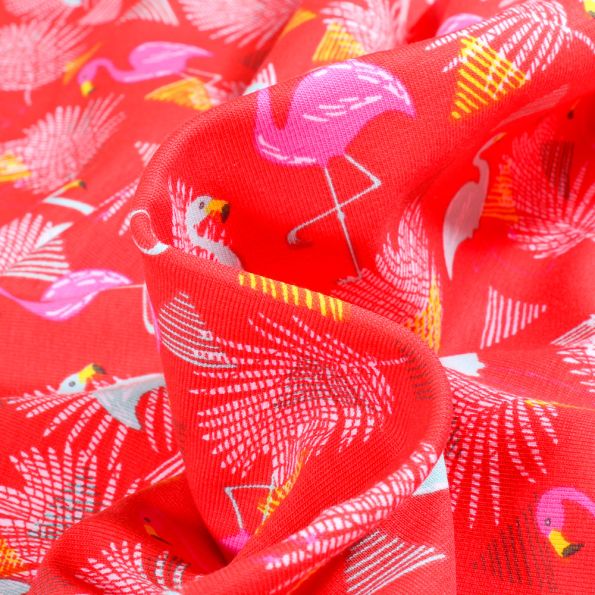 Tissu Jersey Coton Flamants et feuilles sur fond Rouge - Par 10 cm