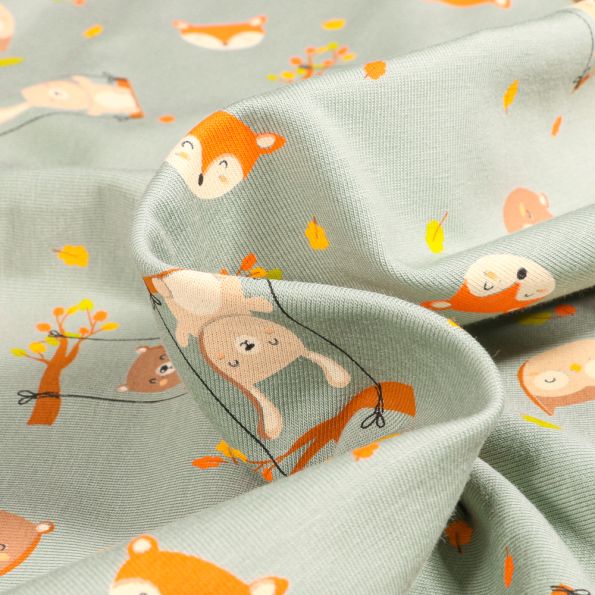 Tissu Jersey Coton Lapins balançoires sur fond Vert amande - Par 10 cm