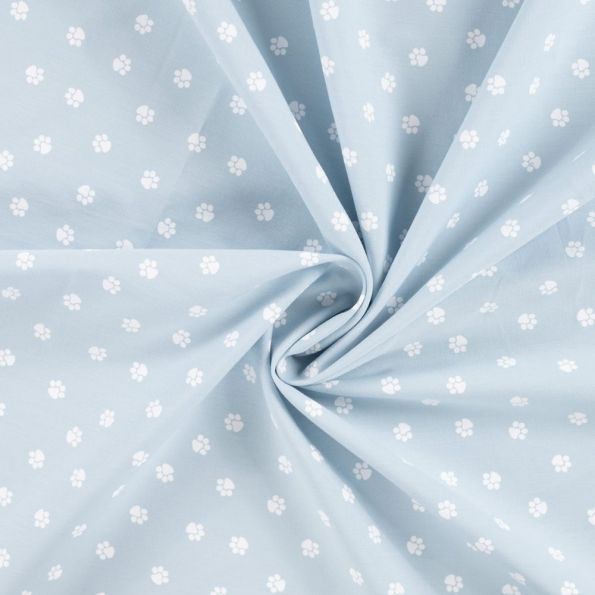 Tissu Popeline de Coton  patounes blanches Zumi sur fond Bleu ciel - Par 10 cm