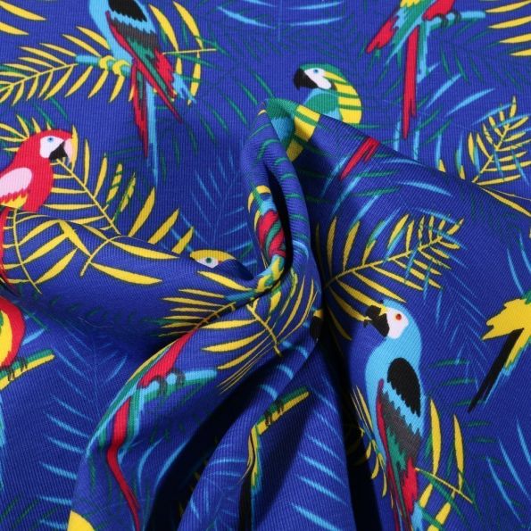 Tissu Jersey Coton Pélicans et feuilles tropicales sur fond Bleu roi - Par 10 cm