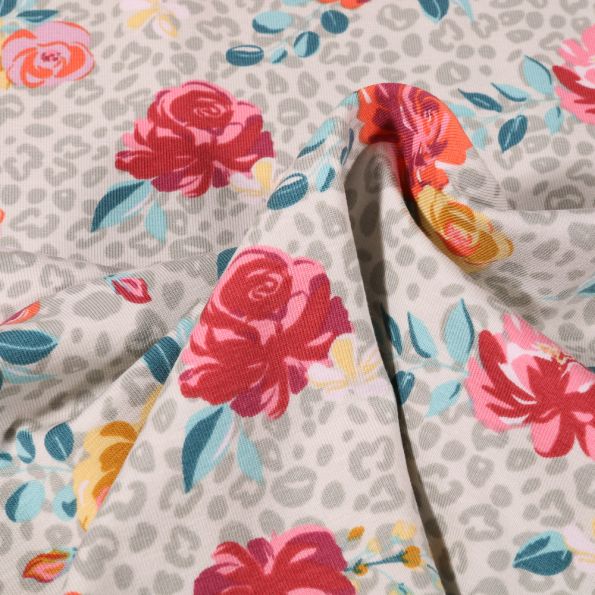 Tissu Jersey Coton Tâches léopard et fleurs colorées sur fond Gris clair - Par 10 cm