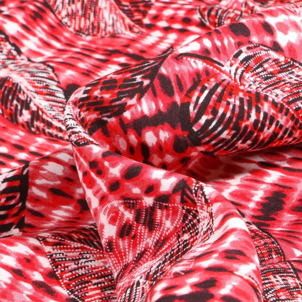 Tissu Viscose légère Plumes et feuilles Noir sur fond Rouge - Par 10 cm