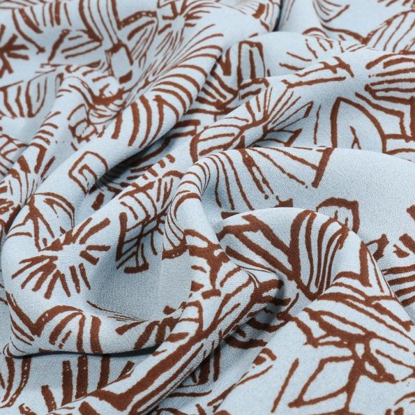 Tissu Crêpe Georgette Makao sur fond Bleu ciel - Par 10 cm