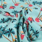 Tissu Jersey Coton Palmiers fleurs d'hibiscus et perroquet sur fond Bleu lagon