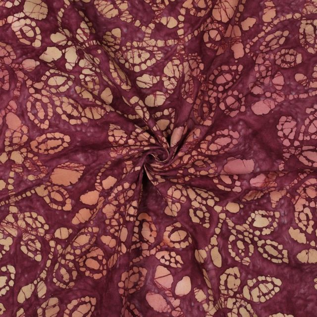 Tissu Batik de Coton galets et pétales Violine sur fond Bordeaux