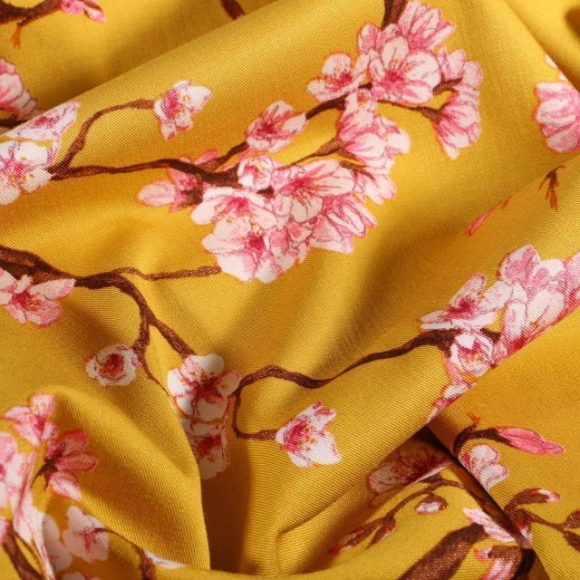 Tissu Viscose Lycra Branches et fleurs de cerisier sur fond Jaune curcuma - Par 10 cm