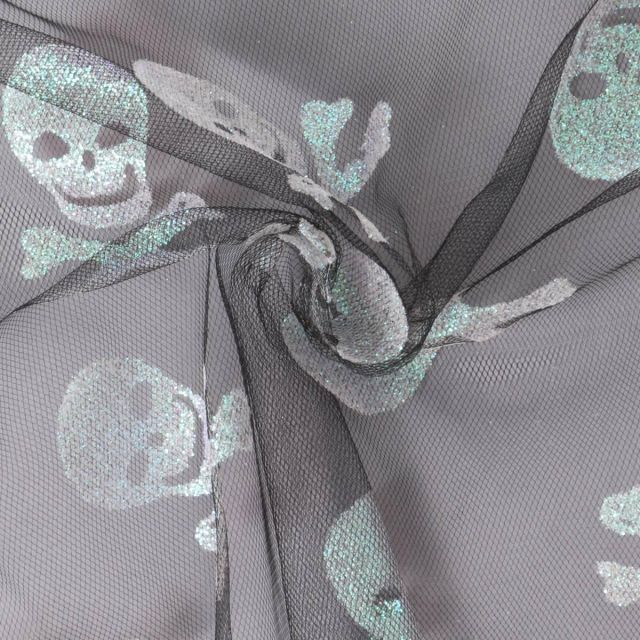 Tissu Tulle souple  Morgana tête de mort paillettes argentés et irisés sur fond Noir