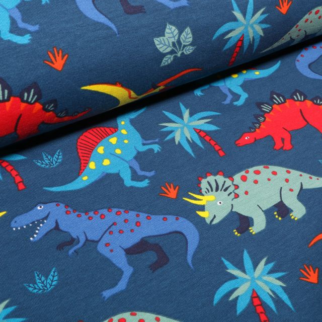 Tissu Jersey Coton French Terry Dinosaures colorés et palmiers sur fond Bleu
