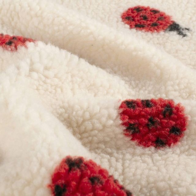 Tissu Fausse fourrure Mouton Lison coccinelles Rouges sur fond Beige