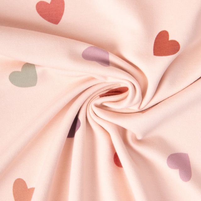 Tissu Sweat léger Coeurs verts, lilas et terracotta sur fond Rose pâle