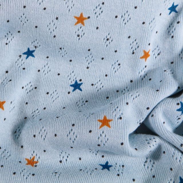 Tissu Jersey ajouré Petites étoiles orange et bleues sur fond Bleu - Par 10 cm