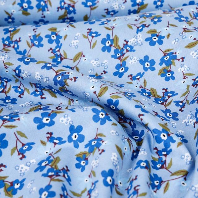 Tissu Popeline de Coton imprimé Petites fleurs bleues sur fond Bleu ciel