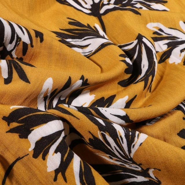 Tissu Viscose texturé Feuilles noires et blanches sur fond Jaune moutarde - Par 10 cm