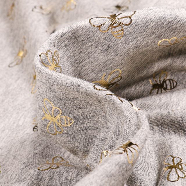 Tissu Jersey Coton Abeilles métallisés dorés sur fond Gris chiné