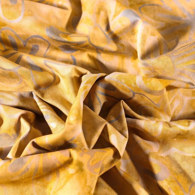 Tissu Batik Pâquerettes sur fond Ocre - Par 10 cm