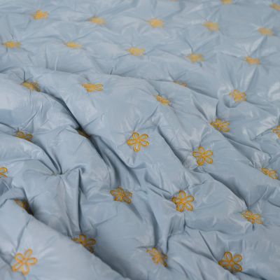 Tissu Matelassé réversible Petites fleurs brodées jaunes sur fond Bleu ciel - Par 10 cm