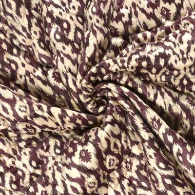 Tissu velours matelassé imprimé envers uni motif ethnique sur fond Bordeaux - Par 10 cm