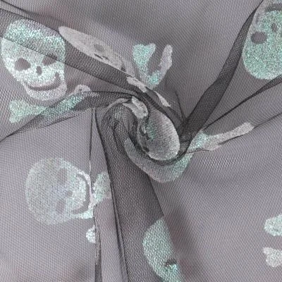 Tissu Tulle souple  Morgana tête de mort paillettes argentés et irisés sur fond Noir - Par 10 cm