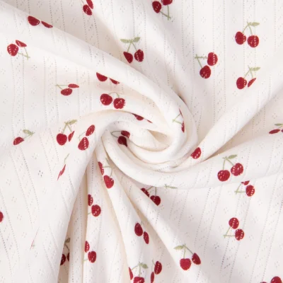 Tissu Jersey 100% Coton ajouré Baby petites cerises sur fond Ecru - Par 10 cm