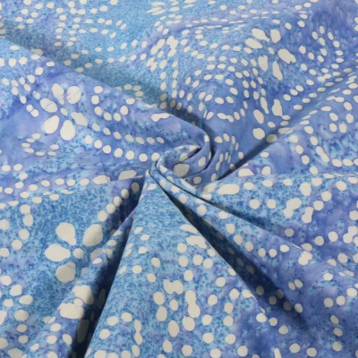 Tissu Voile de Coton Batik fleuris sur fond Bleu lavande - Par 10 cm