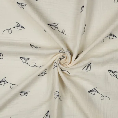 Tissu Double gaze de Coton Avions en papier brodé sur fond Ecru - Par 10 cm
