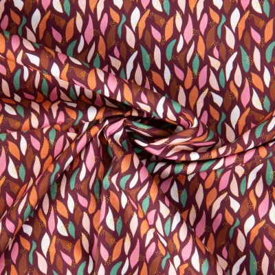 Tissu Popeline de Coton pétales multicolores sur fond Bordeaux - Par 10 cm
