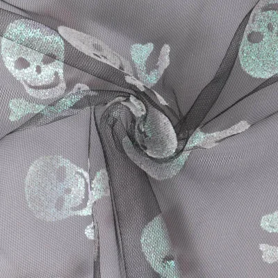 Tissu Tulle souple  Morgana tête de mort paillettes argentés et irisés sur fond Noir - Par 10 cm