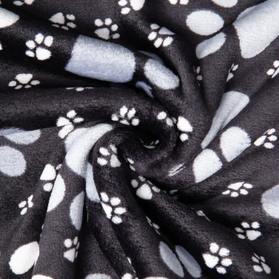 Tissu Doudou imprimé empreintes pattes sur fond Noir - Par 10 cm