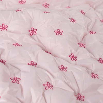 Tissu Matelassé réversible Petites fleurs brodées roses sur fond Rose clair - Par 10 cm