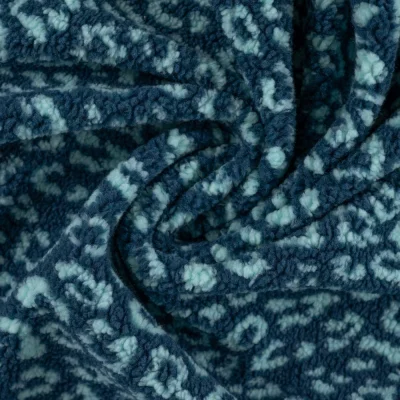 Tissu Teddy Bouclettes motif léopard Bleu ciel sur fond Bleu - Par 10 cm