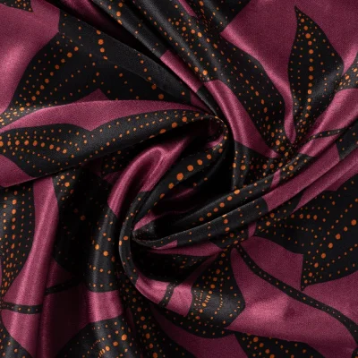 Tissu Viscose Satiné imprimé feuillage Noir et points Orange sur fond Lie de vin - Par 10 cm