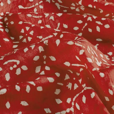 Tissu  Voile de Coton Batik Naya sur fond Rouge - Par 10 cm