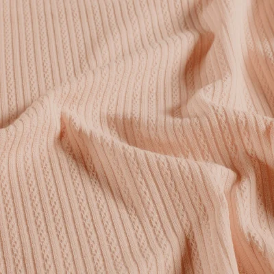 Tissu Maille Bord côte ajouré Chenille Torsadé sur fond Rose clair - Par 10 cm