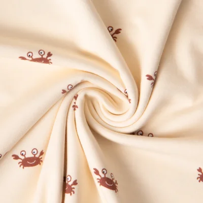 Tissu Jersey Coton imprimé crabes sur fond Beige - Par 10 cm