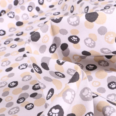 Tissu Coton imprimé QT Fabrics Pattes de chiens beige sur fond Blanc - Par 10 cm