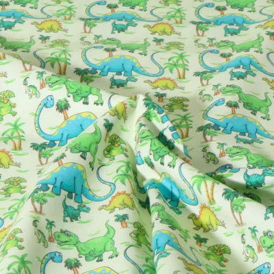 Tissu Coton imprimé Dinoland animaux sur fond Vert pâle - Par 10 cm