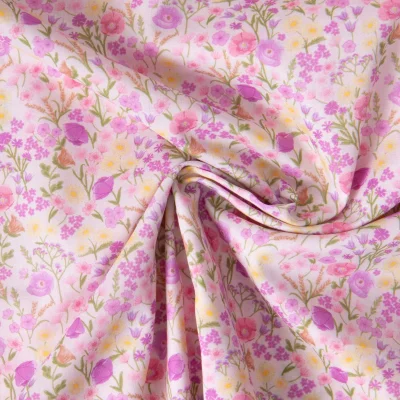 Tissu Popeline de Coton légère imprimé Jardin fleuri rose et lilas sur fond Rose clair - Par 10 cm