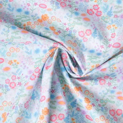 Tissu Popeline de Coton légère Petites fleurs et feuilles aquarelle pastel sur fond Bleu clair - Par 10 cm