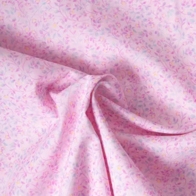 Tissu Popeline de Coton légère Fleur rose mauve et bleu pastel sur fond Rose pastel - Par 10 cm