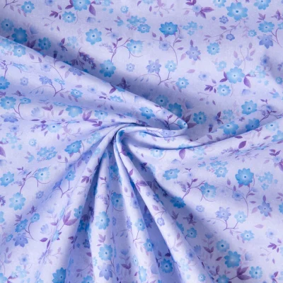 Tissu Popeline de Coton légère Petites fleurs bleues sur fond Lilas - Par 10 cm
