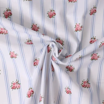 Tissu Popeline de Coton Eglantine rayures Bleues et fleurs Roses sur fond Blanc - Par 10 cm